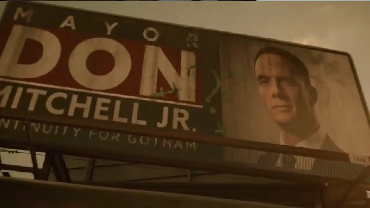 El personaje del cartel publicitario es Mitchell Jr., la primera víctima del Acertijo en The Batman.